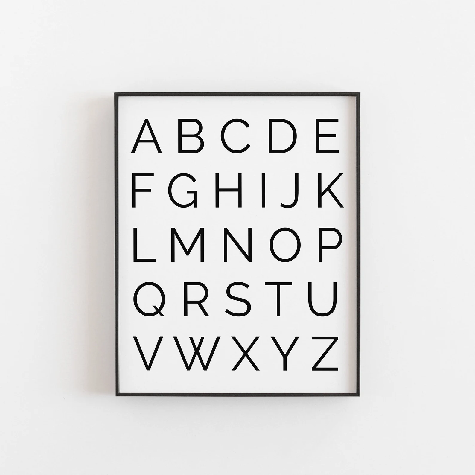 A framed alphabet print, from A to Z, on a light wall.